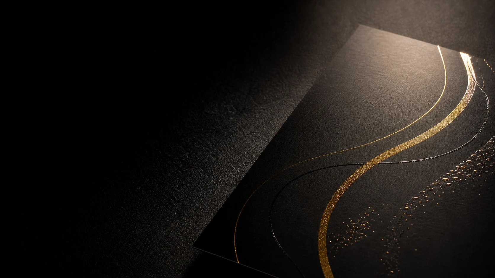 Dettaglio di foil oro e UV a rilievo su carta nera